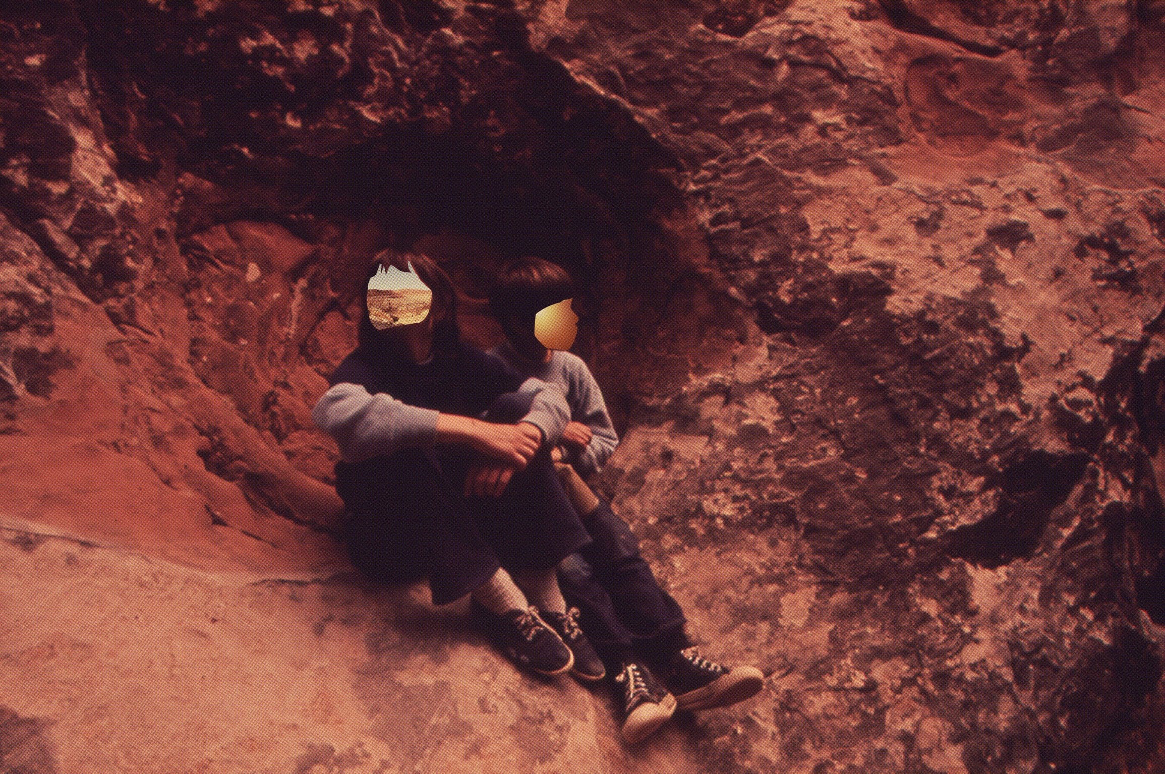 Warm-toned Freaks photograph of two figures among rocks