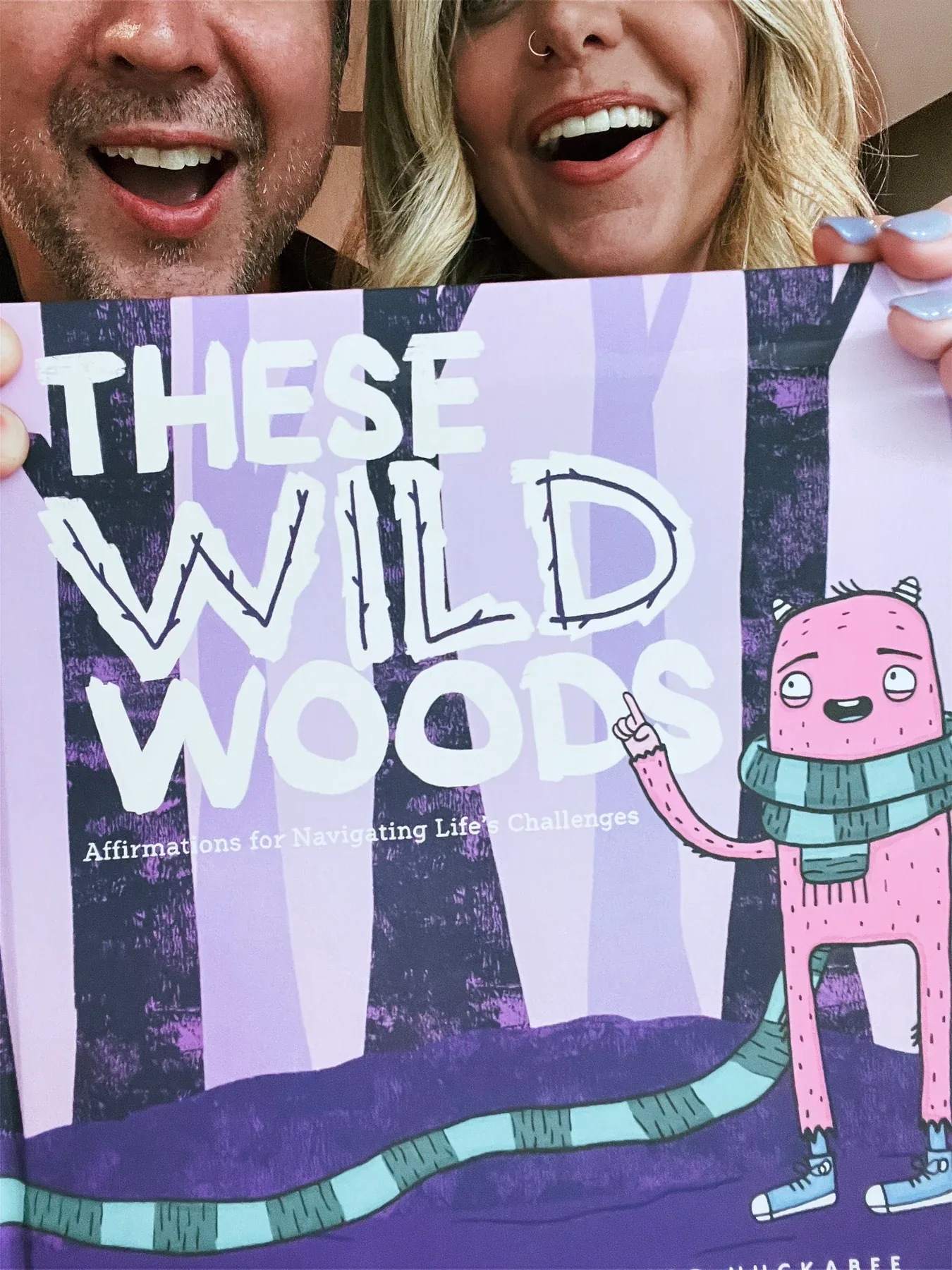 Close-up of Victor Huckabee and Samantha Snow holding These Wild Woods