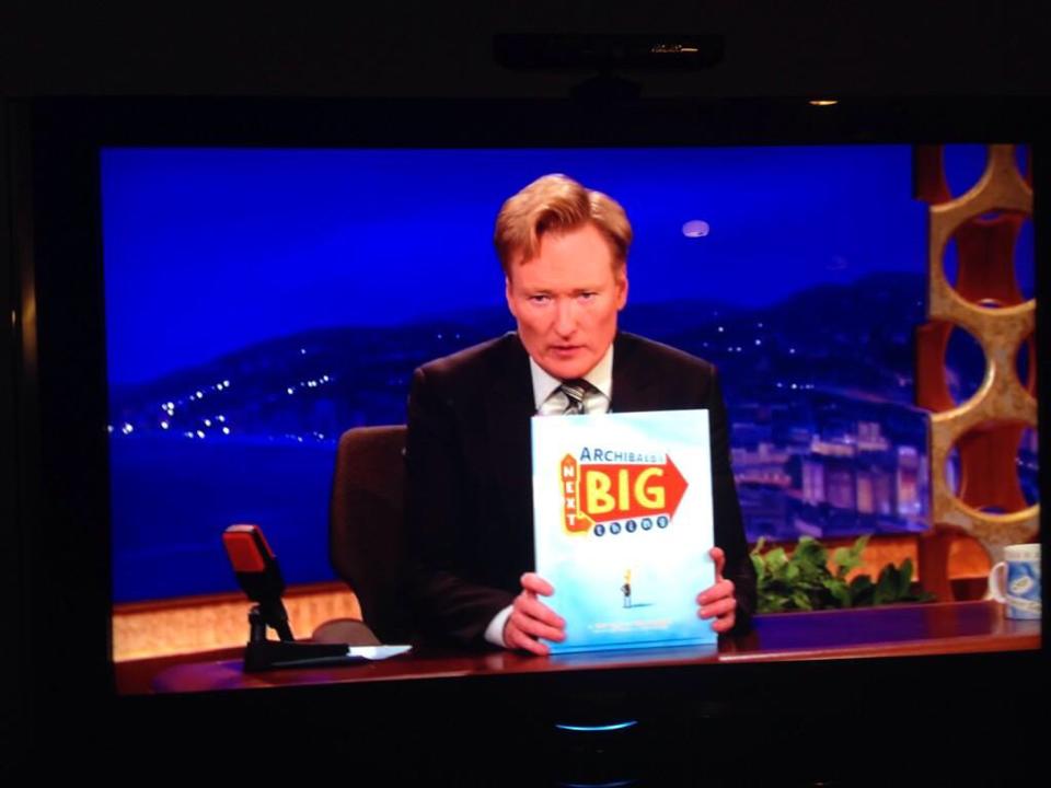 Conan O'Brien holding Archibald's Next Big Thing on television