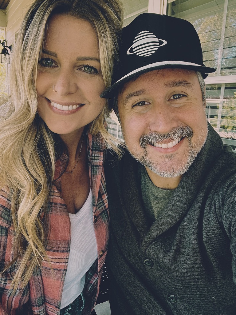 Samantha Snow and Victor Huckabee smiling together on a porch
